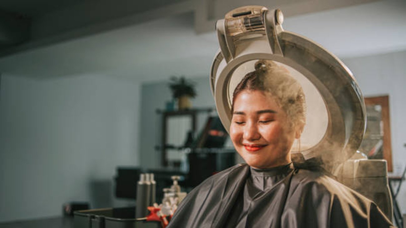 Asian chinese female getting her hair steaming and moisturizing treatment in hair salon
