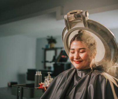 Asian chinese female getting her hair steaming and moisturizing treatment in hair salon